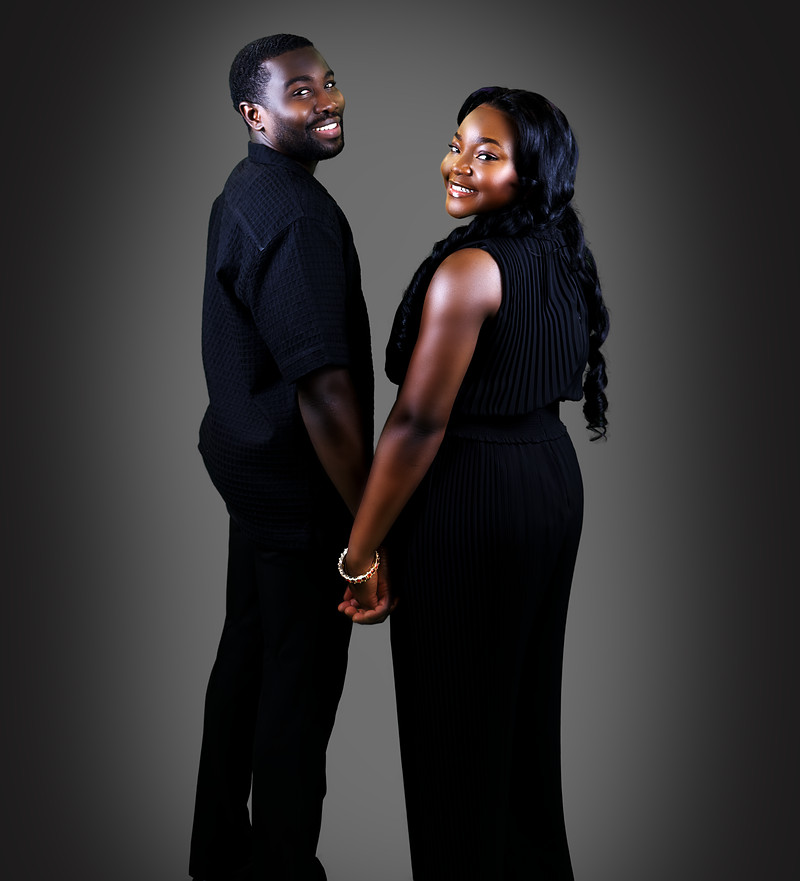 Full-length portrait of the couple holding hands and looking back over their shoulders